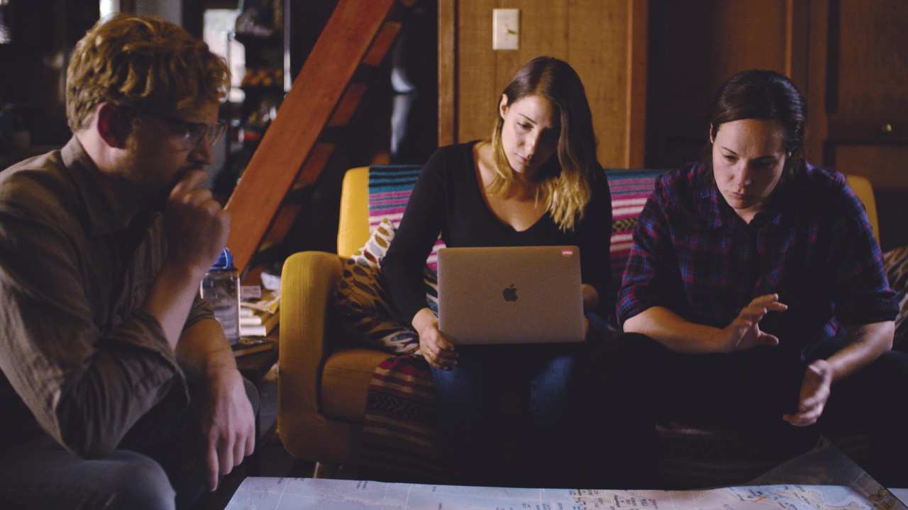 a woman with a laptop and two men sitting together